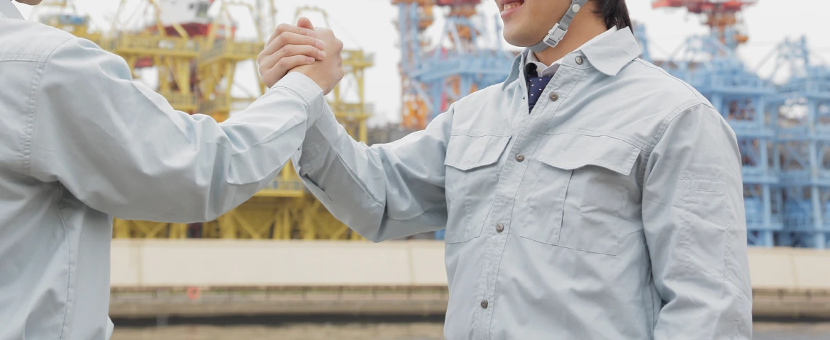 固い握手を交わす建設業の人材